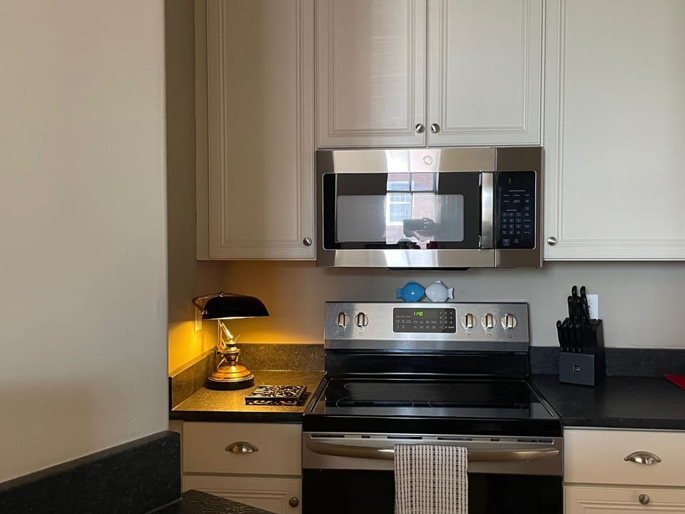 Kitchen appliances include stove, microwave, refrigerator, freezer & toaster
