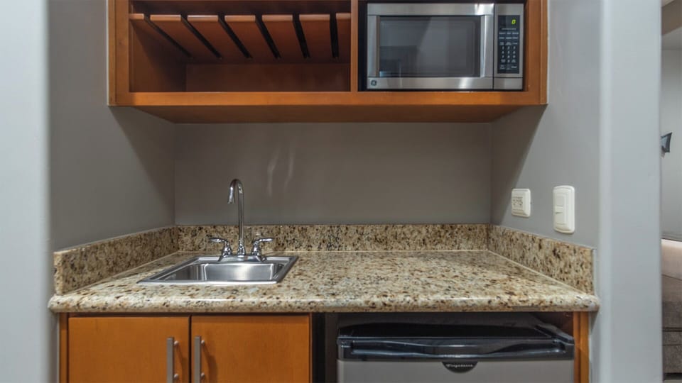 Bar with refrigerator, sink, and microwave.