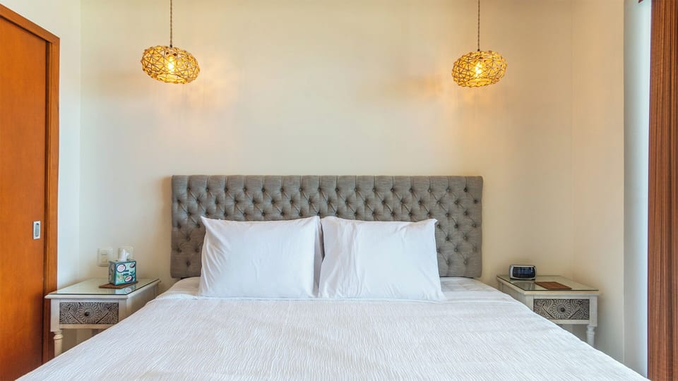 Guest room with king bed and direct access to balcony.