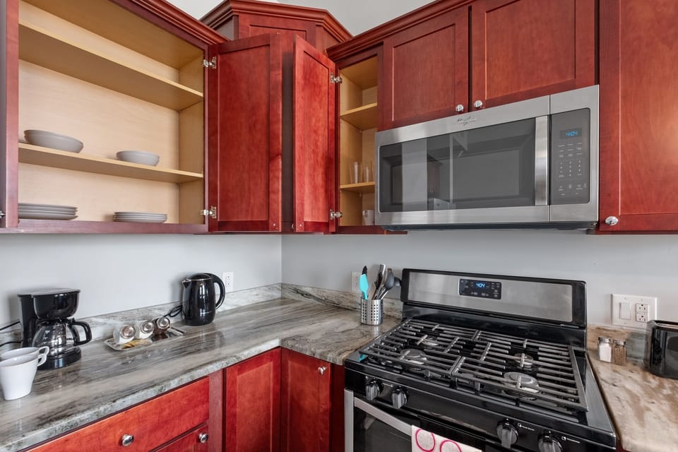 Kitchen featuring gas range, granite counters, and ample cabinetry keeping everything organized.