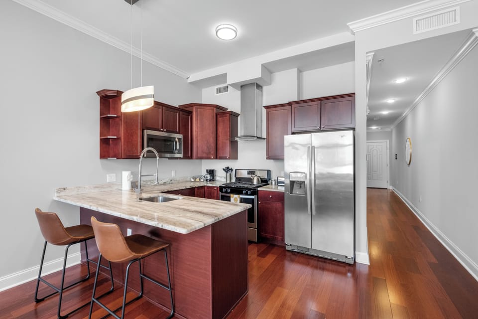 Kitchen featuring cherry cabinetry, breakfast bar, and island seating offering functional cooking space.