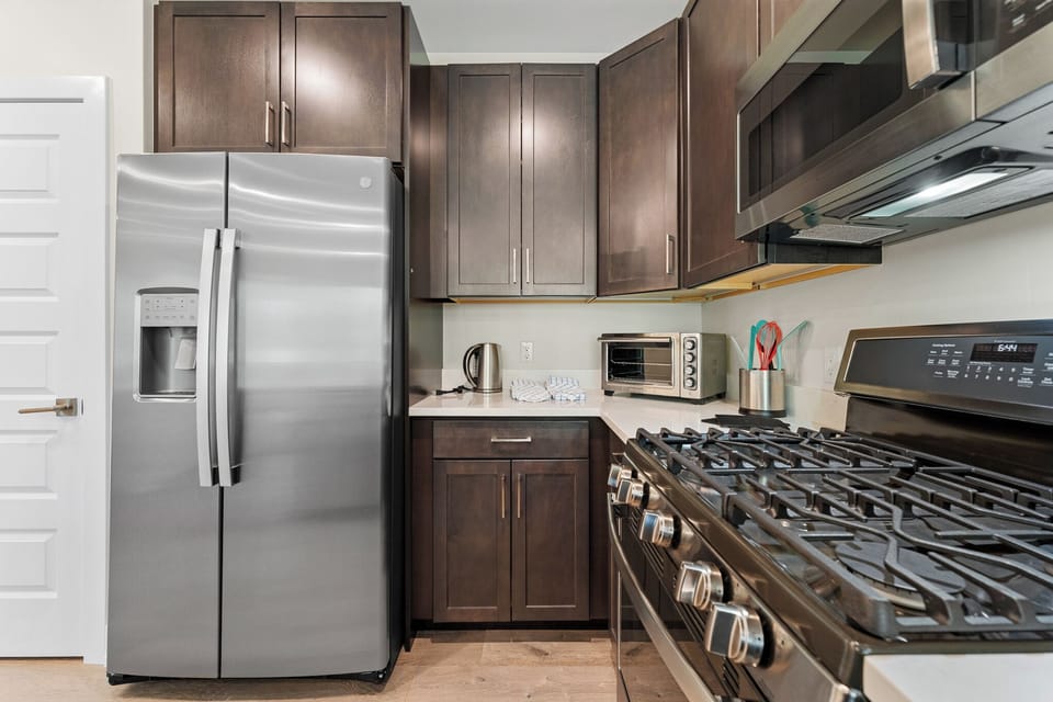 Your fully equipped kitchen features sleek appliances and rich cabinetry, perfect for preparing memorable meals during your stay.