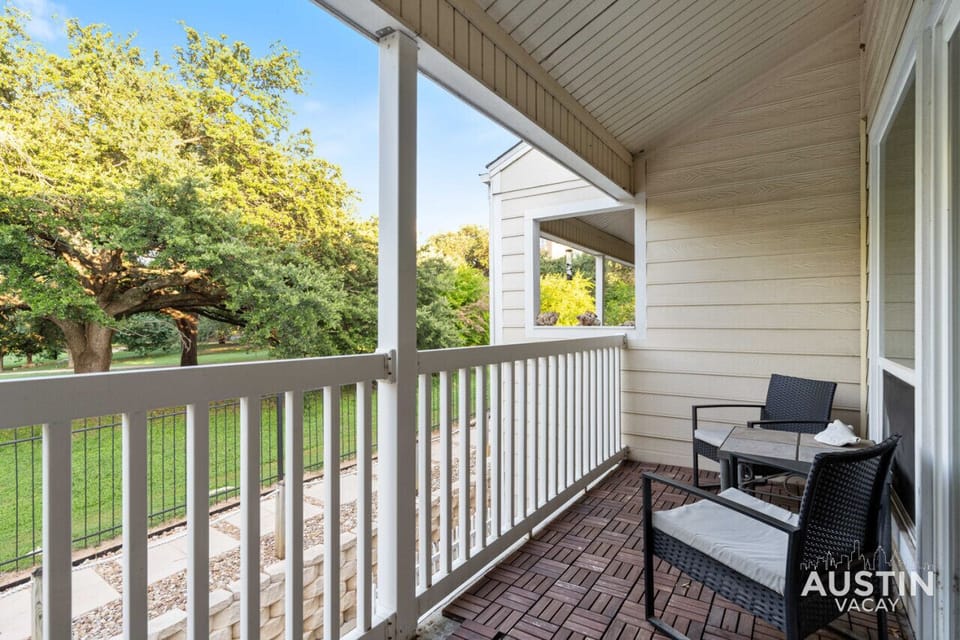 Balcony off of the living room with seating for two and a view of the park