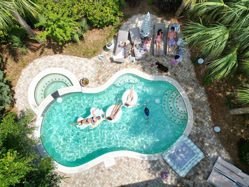 Pool / backyard with plenty of seating, umbrella, tiki bar, gas grill, etc