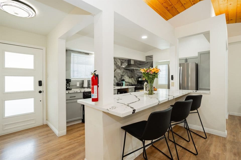 Welcoming Entryway & Breakfast Bar: Enjoy effortless check-in through the secure keyless entry front door before relaxing at the marble-style quartz breakfast bar equipped with high-top counter stools and an open view into the primary kitchen area.