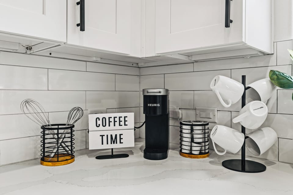 Bright modern coffee bar with Keurig, mugs, and stylish kitchen finishes