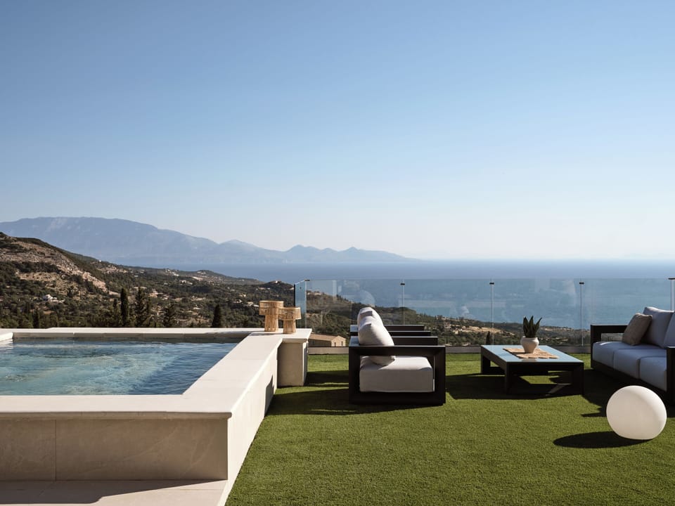 An outdoor build in whirlpool is featured next to the pool.