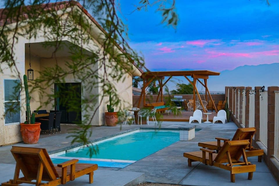 Pool, pergola, lounge chairs, and a cotton candy sky. Your evenings just got a serious upgrade.