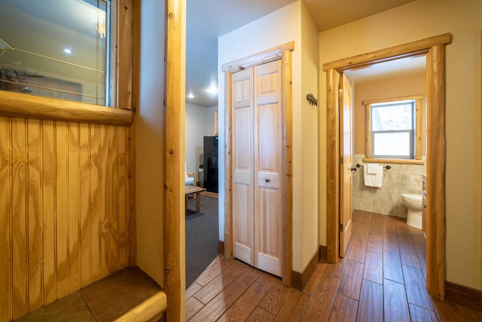 Entrance with a bench to sit on while removing shoes. Views of the coat closet and bathroom entrance.
