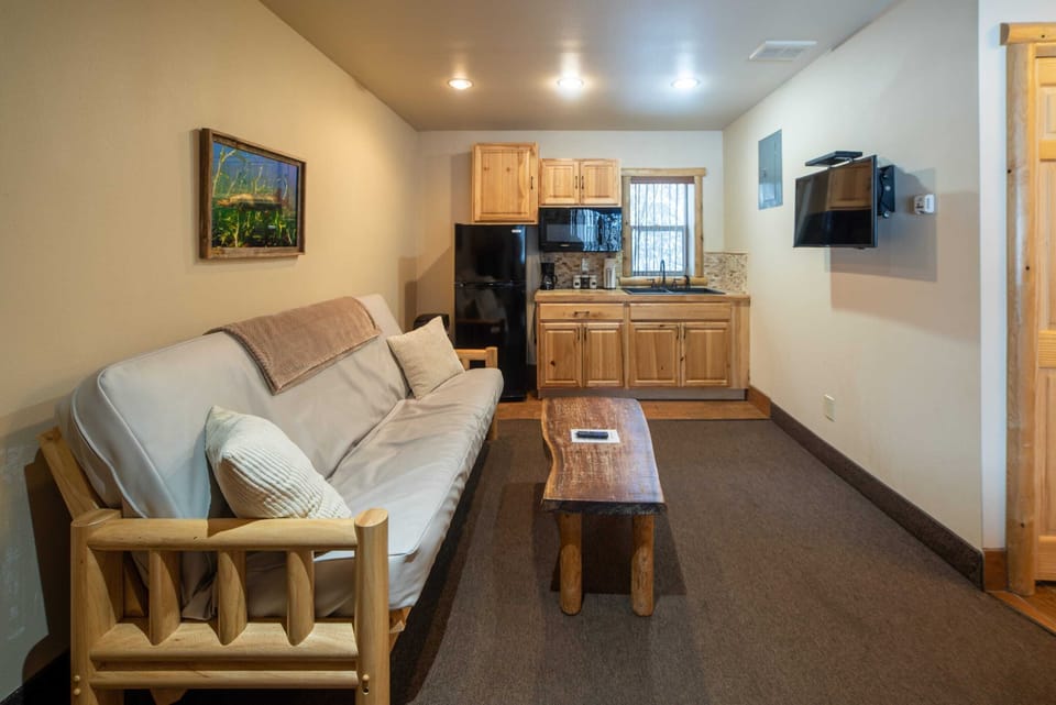 Log framed futon, wood coffee table, kitchenette.