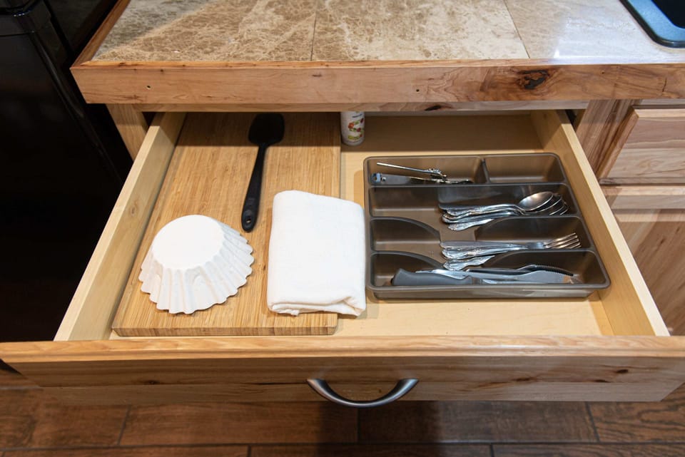 Wood cutting board, stainless steel cutting knifes, and silverware.