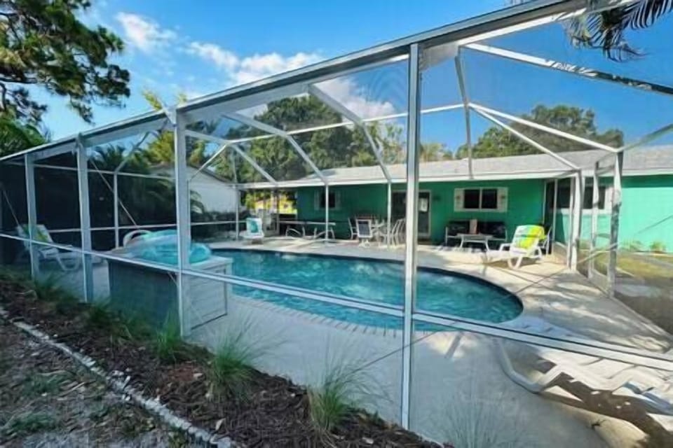 View of private , screened in pool from fenced and landscaped back yard.