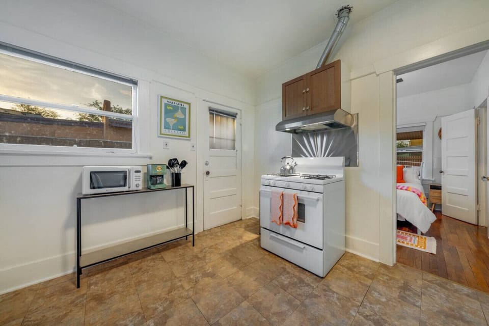 Updated, well-equipped kitchen with charming hood vent, coffee station, and views of the patio
