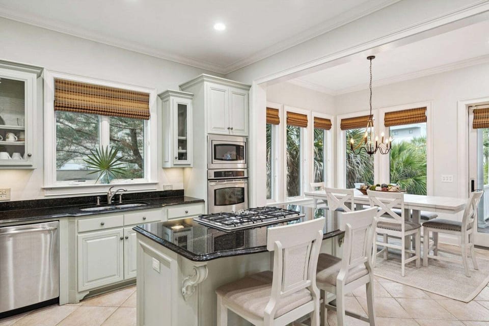 Your gourmet kitchen flows seamlessly into the bright dining nook, where tropical views and elegant finishes create the perfect setting for memorable meals.