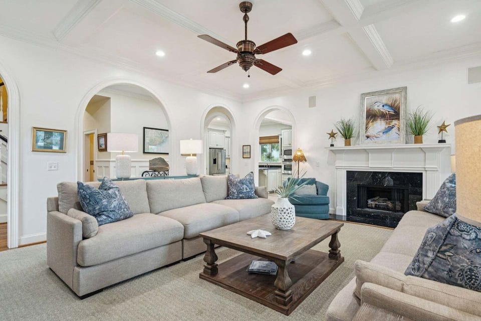 Unwind in your elegant living room featuring plush seating, a cozy fireplace, and sophisticated coastal touches that create the perfect atmosphere for relaxation.