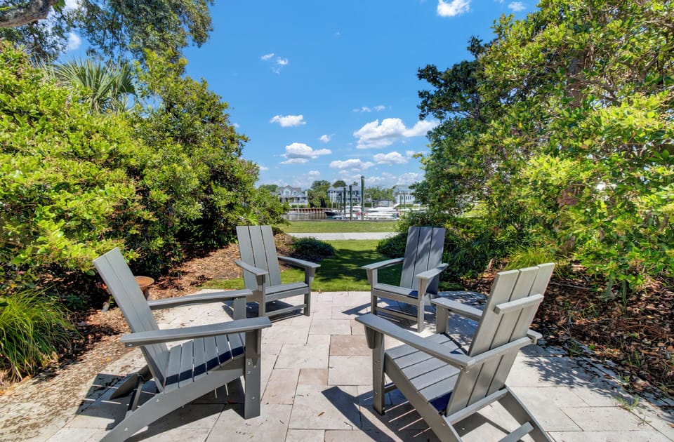 Unwind in this peaceful seating area surrounded by lush landscaping, where comfortable chairs invite you to relax and enjoy tranquil garden views.