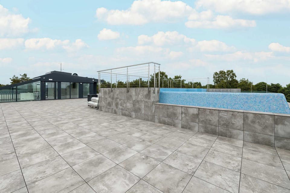 An outdoor relaxation area with paved surfaces and open space near the pool.