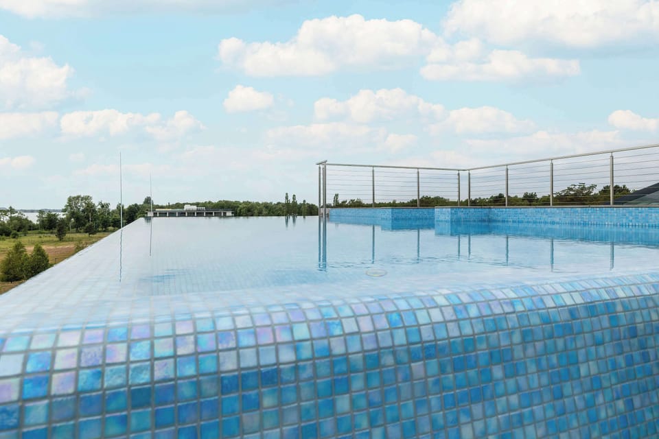 An infinity pool stretching toward the horizon, offering a scenic view under a blue sky.