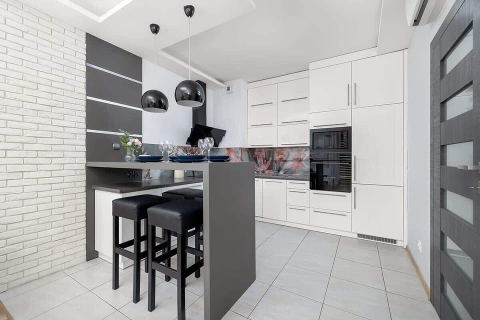 Functional kitchenette with white cabinets.