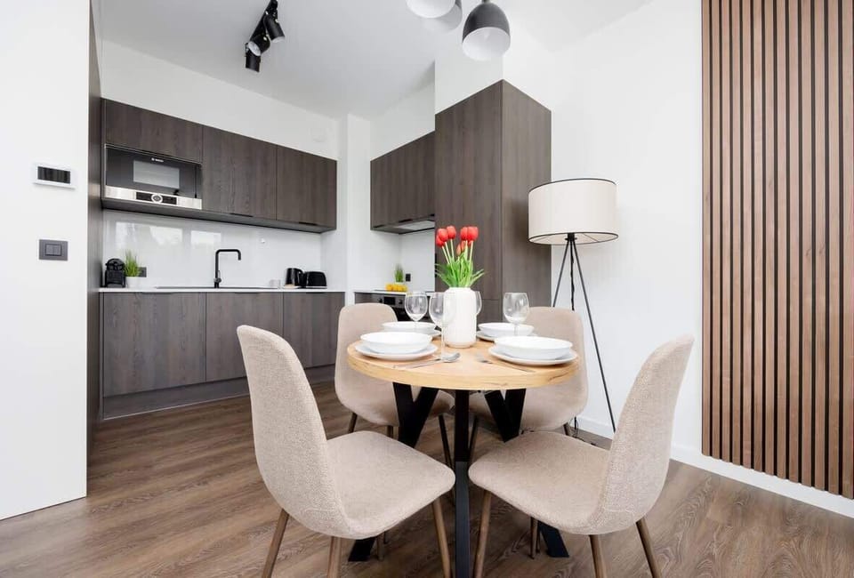 A well-lit living area with a comfortable sofa and a round table set for four.
