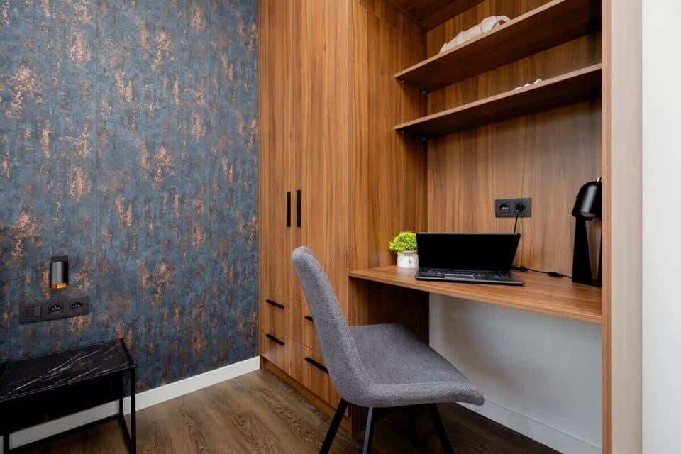 A functional workspace in the bedroom, including a built-in desk, shelves, and a reading chair.

