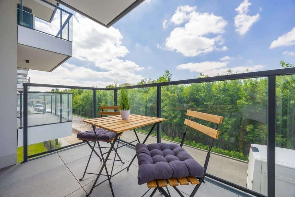 Another balcony view with a broader seating arrangement and glass railings.
