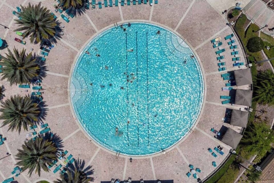 Relax at our beautiful circular pool, surrounded by lush palm trees and colorful lounge chairs. Enjoy a refreshing swim in the crystal-clear water and unwind in the spacious area under the warm sun. Your perfect getaway awaits!