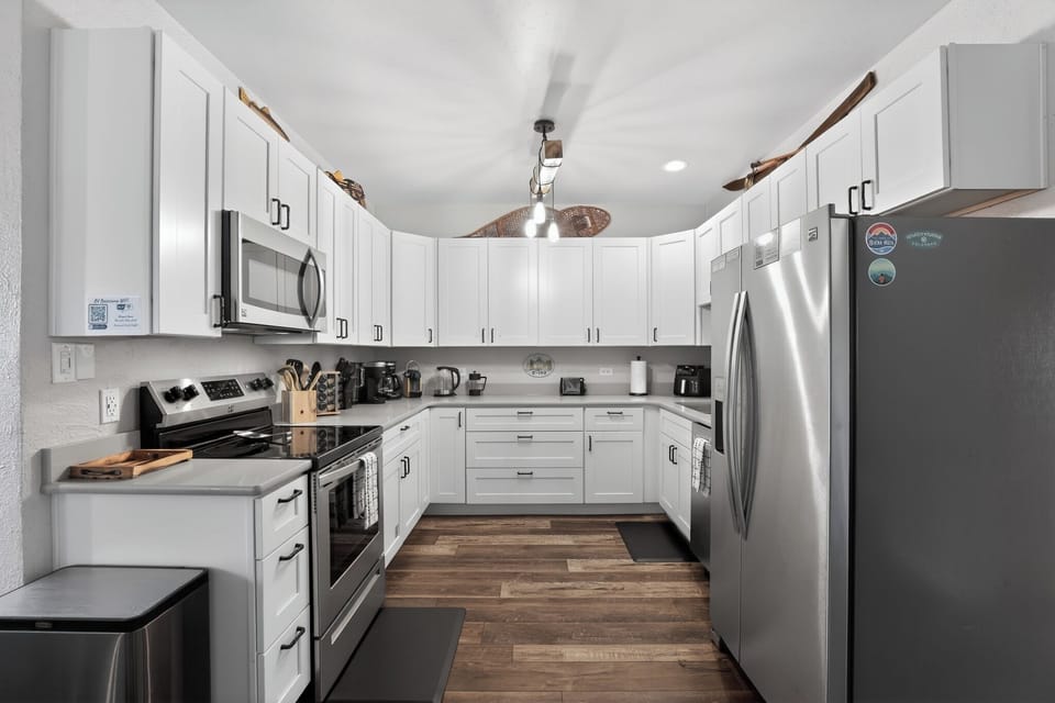 Bright kitchen with oven, microwave, kettle, and coffee station with multiple coffee maker options (Keurig, Nespresso, French Press, traditional) - modern & cozy