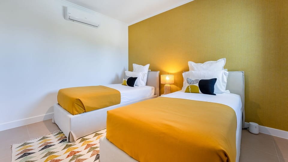 Drift off to sleep in this cozy bedroom with twin beds, accented by warm mustard tones and soft lighting.
#TwinBedroom #ComfortableSleep #LovelyStay