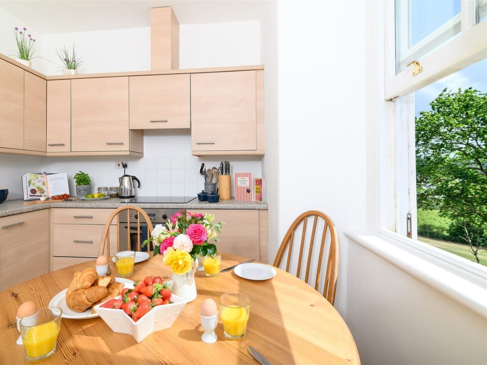 Bright spacious, well equipped kitchen with circular farmhouse table.