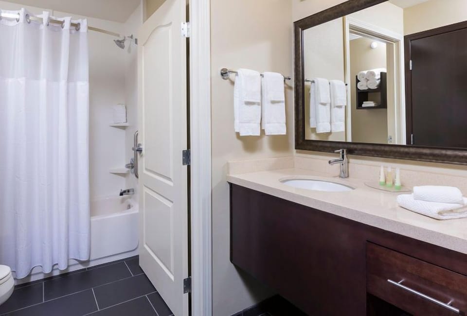 Desk, ergonomic chair, and flat-screen TV set up in the suite for working from your room