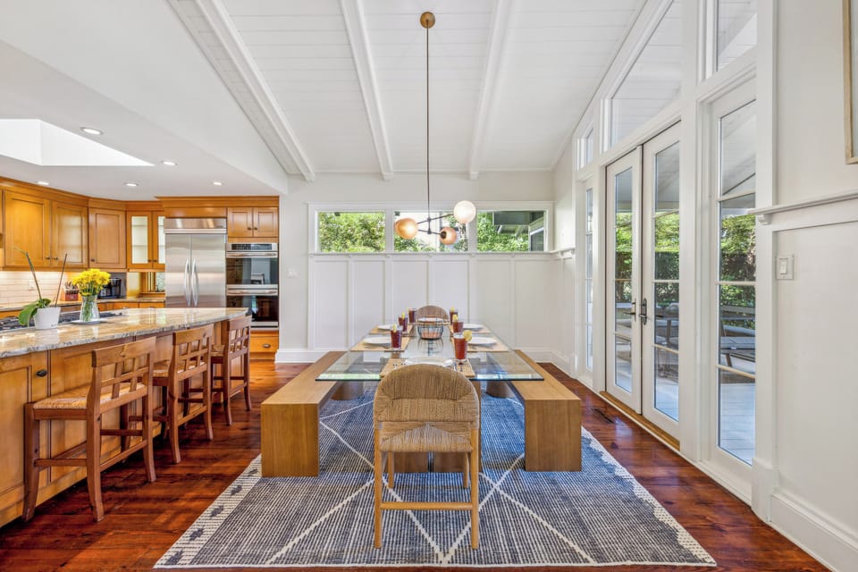 Just beyond the island, a charming dining table invites intimate meals and engaging conversations.