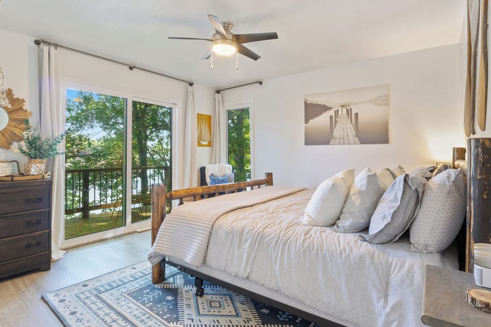 Bright and serene master bedroom with lake views and private balcony access.