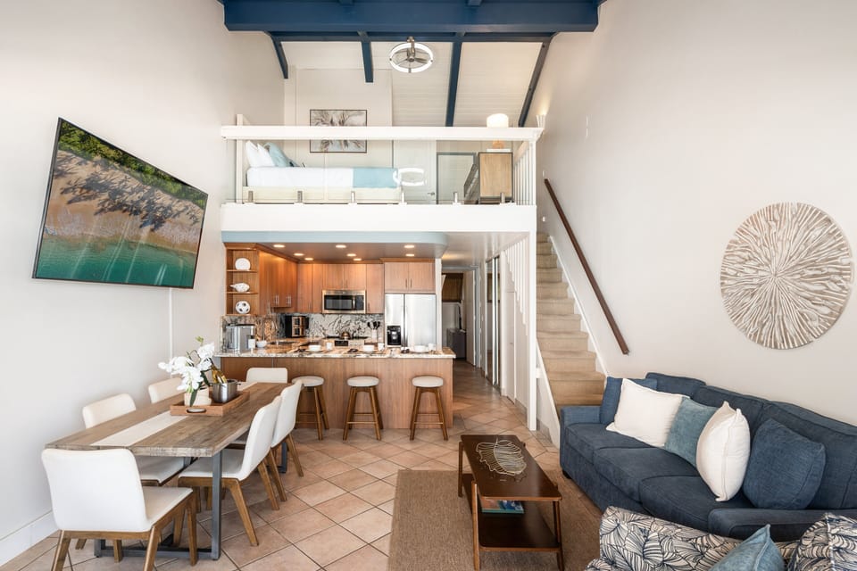 Spacious open-concept layout connecting the living room, dining area, kitchen, and loft, all highlighted by soaring ceilings and ocean views.