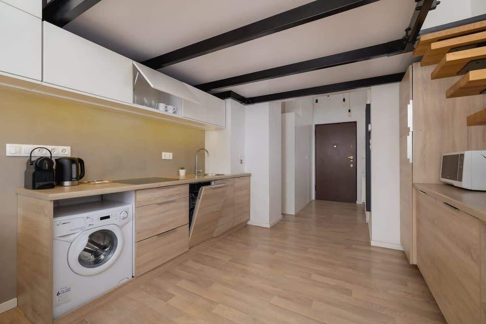 Fully equipped kitchen with yellow backsplash – Includes oven, fridge, and washing machine.

