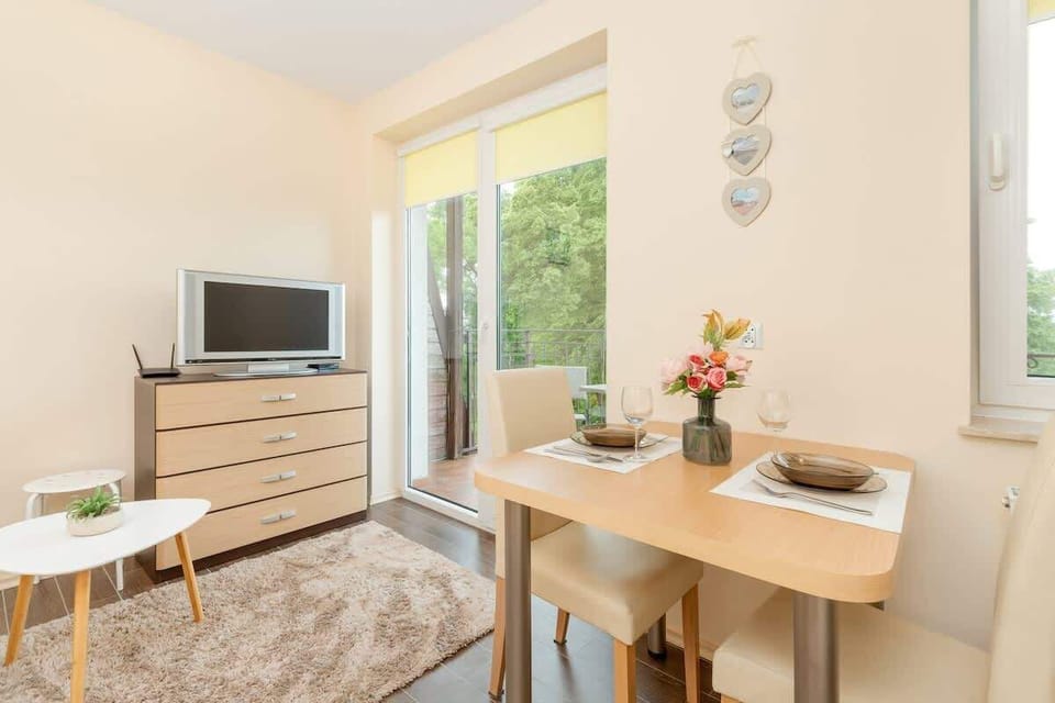 A combined dining and sleeping space with a wooden table and bed.

