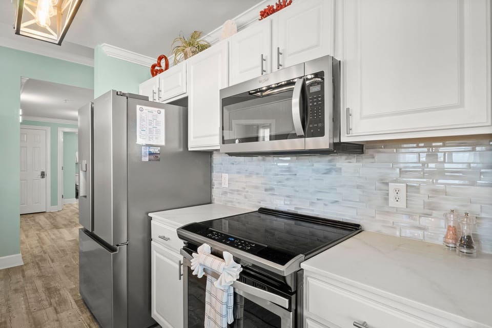 The updated kitchen features a large kitchen island, granite countertops, stainless-steel appliances, spacious pantry, and everything you need to prepare meals for family & friends.