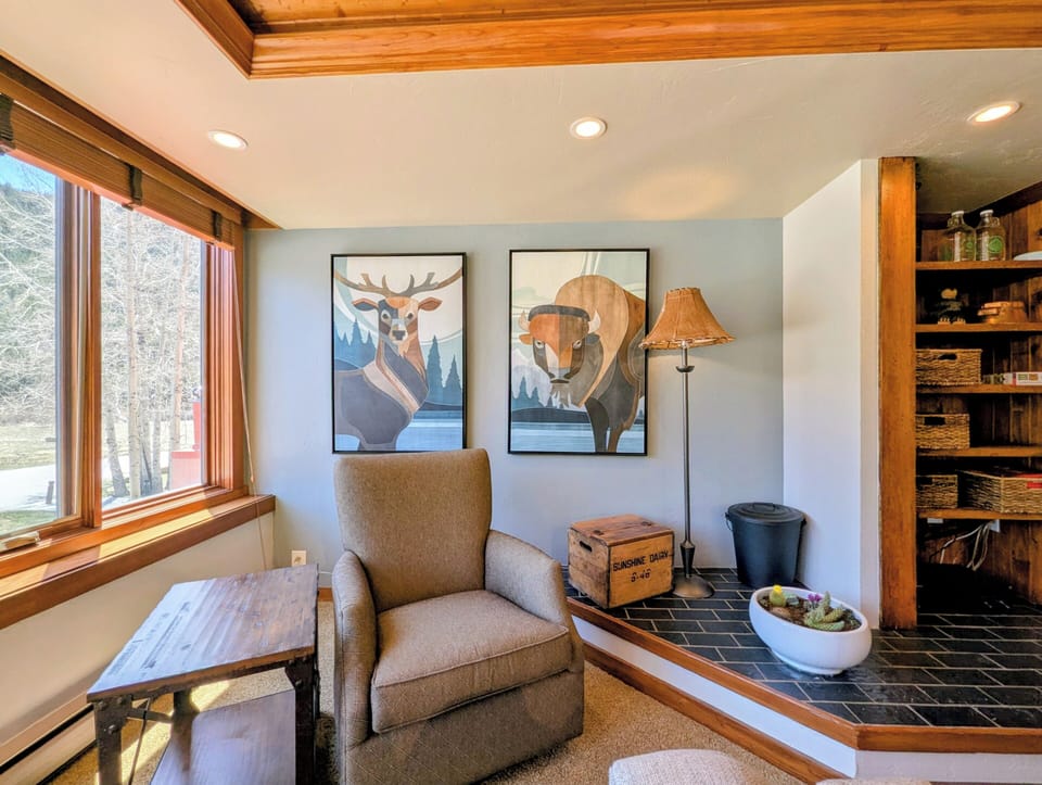 Settle into your cozy reading nook, where natural light streams through and rustic charm meets modern comfort—your perfect retreat for morning coffee or afternoon relaxation.