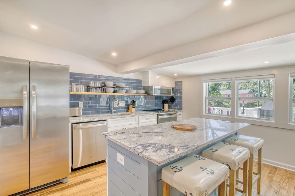 Completely renovated kitchen with stainless steel appliances, granite counter tops and bar seating for 3.
