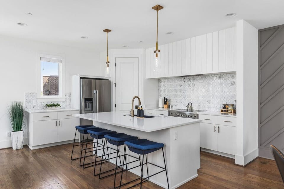 High-end appliances, large pantry, and all the cooking supplies you might need in this bright & fresh kitchen with seating for four at the island.