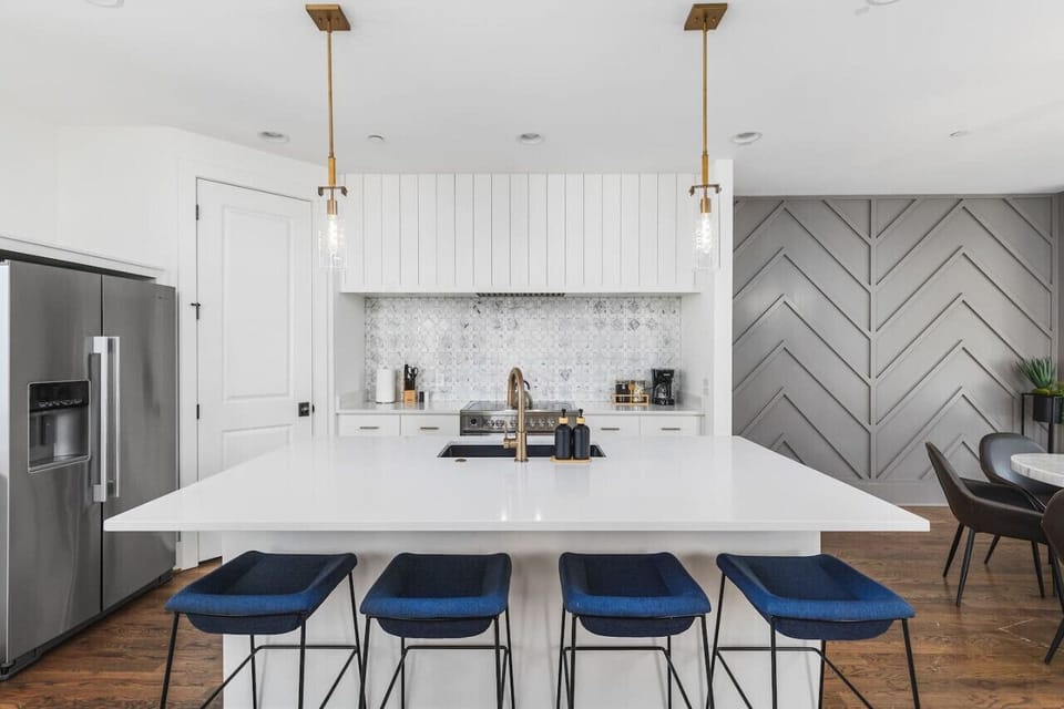 High-end appliances, large pantry, and all the cooking supplies you might need in this bright & fresh kitchen with seating for four at the island.