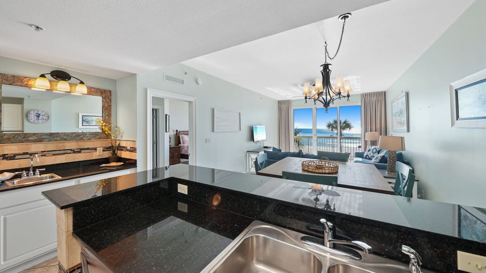 Your fully equipped kitchen flows into a bright living area where ocean views and coastal breezes create the perfect backdrop for memorable vacation moments.