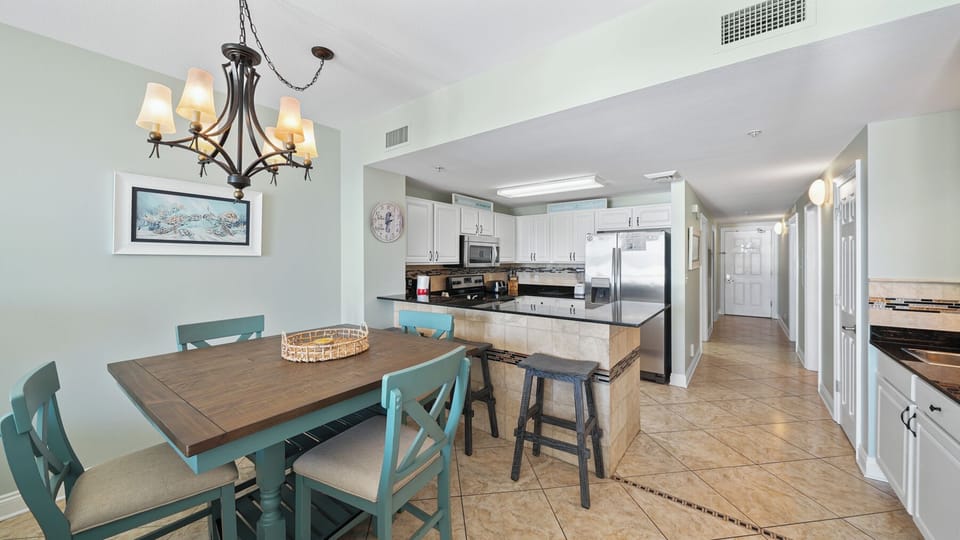 Gather with loved ones in this bright, open kitchen and dining space featuring modern appliances and charming coastal touches.