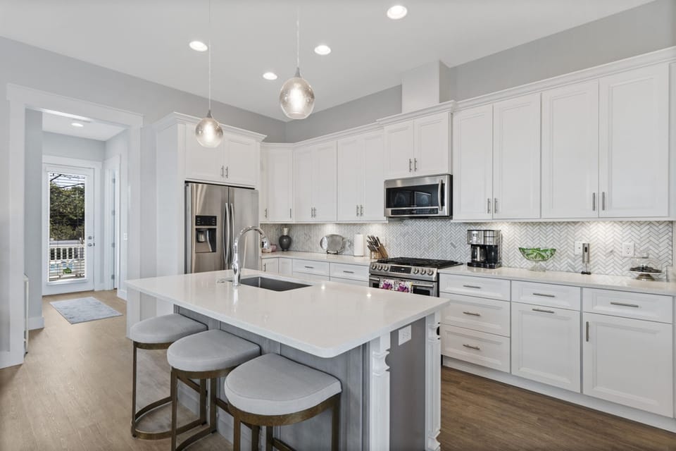 Your spacious gourmet kitchen features pristine white cabinetry, gleaming quartz countertops, and premium stainless appliances for effortless meal preparation.
