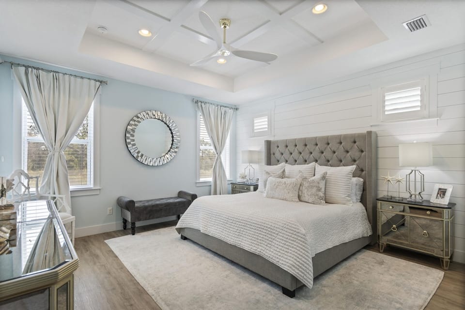 Unwind in your elegant master suite with luxurious linens, soft coastal hues, and gentle ceiling fan keeping you comfortable all night.