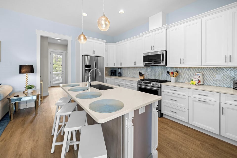 Your gourmet kitchen awaits with gleaming quartz counters, stainless appliances, and a spacious island perfect for morning coffee or evening meals together.