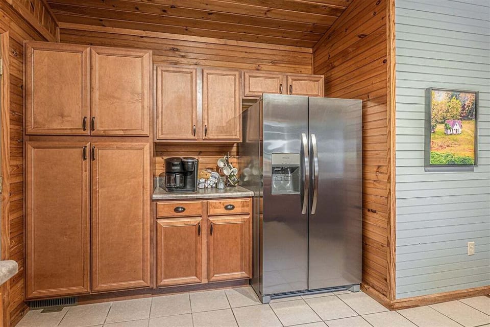 Stainless fridge and pantry area with storage and appliances.