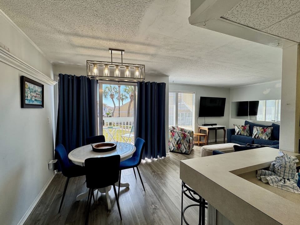 Gather around your bright dining table with garden views, then unwind in the cozy living room with dual TVs for entertainment.