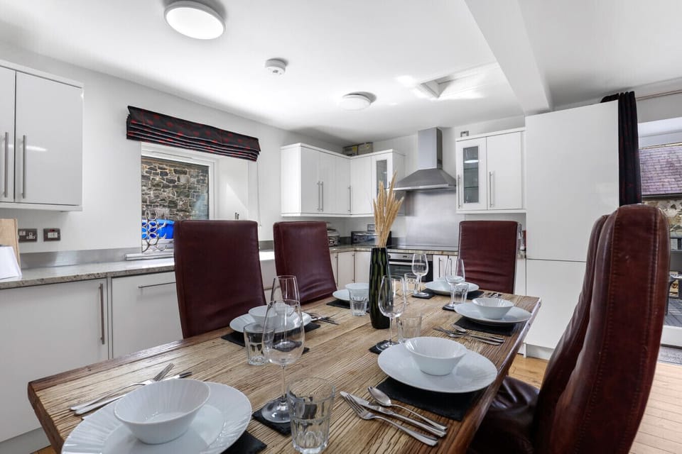 Dining table for six beside the fitted kitchen