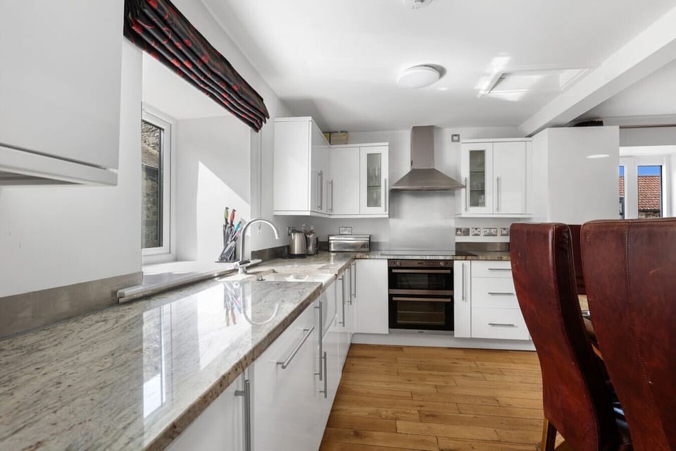White kitchen with granite worktops and Belfast sink